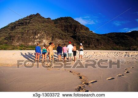 Stock Image - A family plays bocce ball alone an empty stretch of Polihale State Park beach, Kauai, Hawaii, USA. Fotosearch