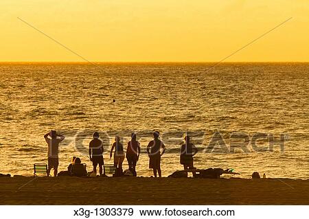 Stock Photo - A family plays bocce ball alone an empty stretch of Polihale State Park beach, Kauai, Hawaii, USA. Fotosearch