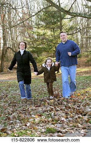 Stock Photograph - a family running and having fun in a park in winter. Fotosearch