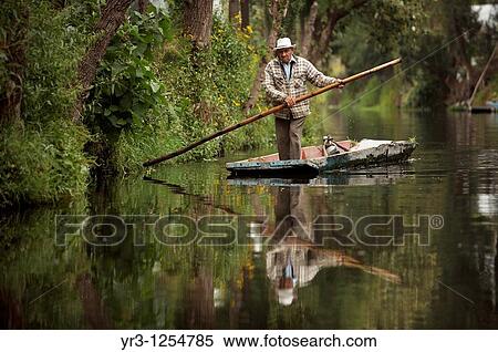 A farmer navigates through the water canals of San Gregorio Atlapulco village in Xochimilco, southern Mexico City View Large Photo Image Stock Photography - A farmer navigates through the water canals of San Gregorio Atlapulco village in Xochimilco, southern Mexico City. Fotosearch