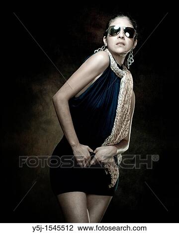 A fashionable young woman wearing a one-piece and sunglasses in the studio View Large Photo Image Stock Image - A fashionable young woman wearing a one-piece and sunglasses in the studio. Fotosearch