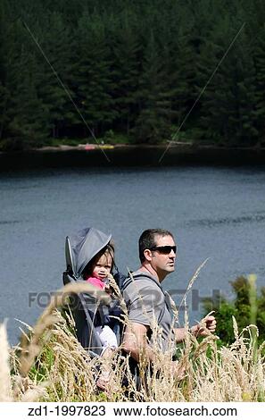 Stock Image - A father and his child are hiking in the nature.. Fotosearch