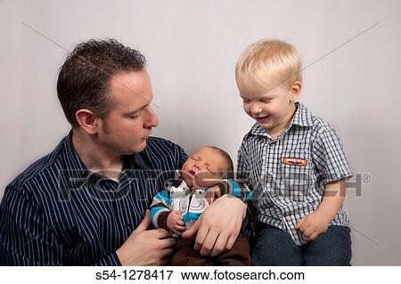 A father with his two-year-old and newborn sons View Large Photo Image Stock Photo - A father with his two-year-old and newborn sons. Fotosearch