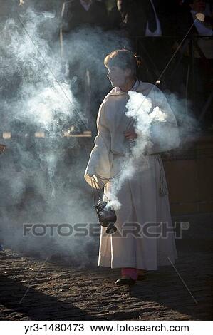Stock Image - A female acolyte spreads incense during an Easter Holy Week procession in Prado del Rey, Andalusia, Spain, April 24, 2011. Fotosearch