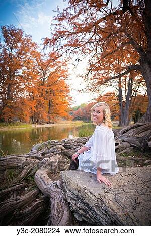 A female caucasian teenager is sitting on a rock next to Cypress tree roots and enjoying nature at the Frio River near Concan, Texas, USA. View Large Photo Image Picture - A female caucasian teenager is sitting on a rock next to Cypress tree roots and enjoying nature at the Frio River near Concan, Texas, USA.. Fotosearch
