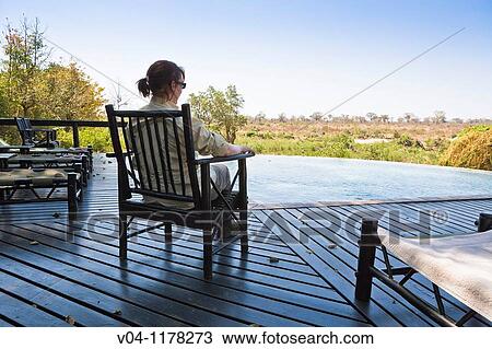 A female guest enjoying the quiet and the view of the bush at a lodge in South Africa View Large Photo Image Stock Image - A female guest enjoying the quiet and the view of the bush at a lodge in South Africa. Fotosearch