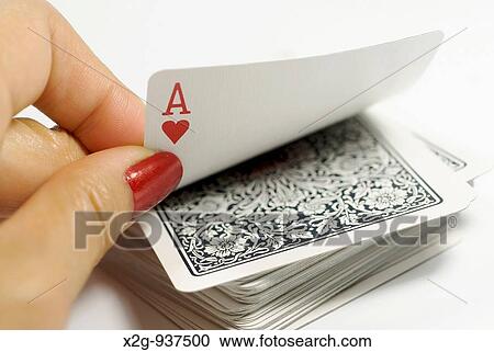 Stock Image - A female hands picking ace from a card stack. Fotosearch