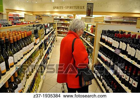 A female shopper in a liquor store, Canada View Large Photo Image Picture - A female shopper in a liquor store, Canada. Fotosearch
