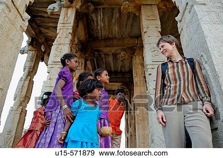 A few indian girls talking to a German mid-aged female tourist at Large Ganesha Temple in Hampi, Karnataka, India 2005. View Large Photo Image Stock Photo - A few indian girls talking to a German mid-aged female tourist at Large Ganesha Temple in Hampi, Karnataka, India 2005.. Fotosearch