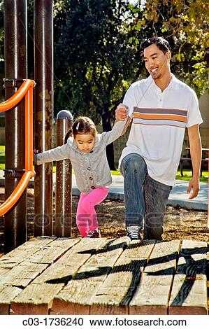 Stock Image - A Filipino-American father and his four-year-old daughter visit a playground in Cerritos, CA.. Fotosearch