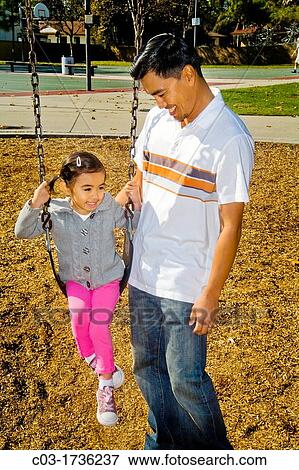 A Filipino-American father and his four-year-old daughter visit a playground in Cerritos, CA. View Large Photo Image Stock Photo - A Filipino-American father and his four-year-old daughter visit a playground in Cerritos, CA.. Fotosearch