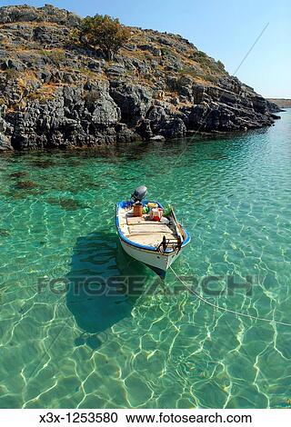 Stock Image - A fisherman boat docked in Lindos bay Island of Rhodes Greece. Fotosearch