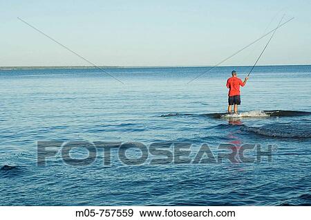A fisherman fly-fishing for Trevally and Queenfish in Darwin, Northern Territory, Australia View Large Photo Image Stock Photo - A fisherman fly-fishing for Trevally and Queenfish in Darwin, Northern Territory, Australia. Fotosearch