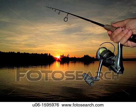 A fishing rod and reel with a sunset on a lake in background View Large Photo Image Stock Photograph - A fishing rod and reel with a sunset on a lake in background. Fotosearch