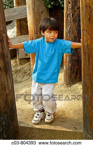 Stock Image - A five-year-old? blended? Asian-Caucasian boy amuses himself in a Laguna Beach, CA, playground. Fotosearch