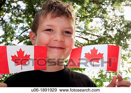 a five year old boy holding up Canadian flags in celebration of Canada Day July 1st in Canada View Large Photo Image Stock Photo - a five year old boy holding up Canadian flags in celebration of Canada Day July 1st in Canada. Fotosearch