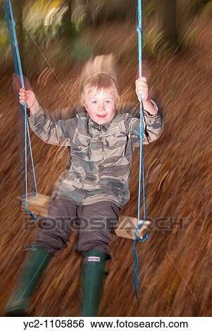 A five year old boy on a swing showing movement using rear curtain sync flash method in the Uk View Large Photo Image Stock Photograph - A five year old boy on a swing showing movement using rear curtain sync flash method in the Uk. Fotosearch