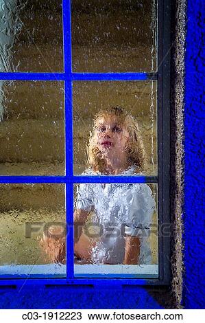 A five-year-old girl looks out her window on a rainy night in suburban Lake Forest, CA View Large Photo Image Stock Image - A five-year-old girl looks out her window on a rainy night in suburban Lake Forest, CA. Fotosearch