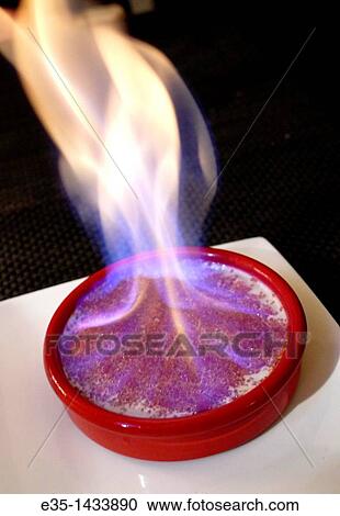 Stock Image - A flaming Creme Brulee is served as a dessert in many parts of France. Fotosearch