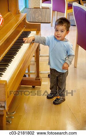 A four-year-old Asian American boy has fun trying to play a piano in Huntington Beach, CA. MODEL RELEASE. View Large Photo Image Stock Image - A four-year-old Asian American boy has fun trying to play a piano in Huntington Beach, CA. MODEL RELEASE.. Fotosearch