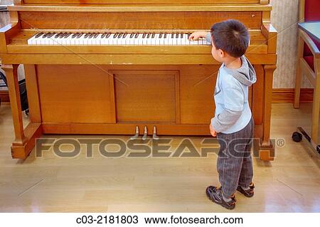 A four-year-old Asian American boy has fun trying to play a piano in Huntington Beach, CA. MODEL RELEASE. View Large Photo Image Stock Image - A four-year-old Asian American boy has fun trying to play a piano in Huntington Beach, CA. MODEL RELEASE.. Fotosearch