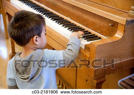 A four-year-old Asian American boy has fun trying to play a piano in Huntington Beach, CA. MODEL RELEASE. View Large Photo Image Stock Photograph - A four-year-old Asian American boy has fun trying to play a piano in Huntington Beach, CA. MODEL RELEASE.. Fotosearch