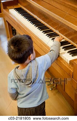 A four-year-old Asian American boy has fun trying to play a piano in Huntington Beach, CA. MODEL RELEASE. View Large Photo Image Stock Photography - A four-year-old Asian American boy has fun trying to play a piano in Huntington Beach, CA. MODEL RELEASE.. Fotosearch
