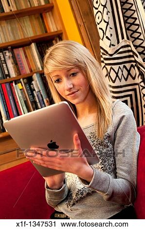 A fourteen year old teenage girl using an Apple iPad to read Facebook and email at home, UK View Large Photo Image Stock Image - A fourteen year old teenage girl using an Apple iPad to read Facebook and email at home, UK. Fotosearch