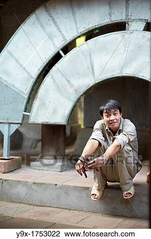 A gardner squats on a step while holding pruning sheers during his break View Large Photo Image Stock Image - A gardner squats on a step while holding pruning sheers during his break. Fotosearch