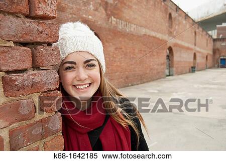 a girl, 16, smiles by a brick wall View Large Photo Image Stock Photography - a girl, 16, smiles by a brick wall. Fotosearch