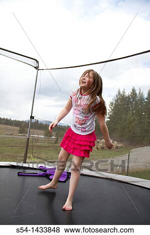 A girl, 5-10, jumping on a trampoline in Coeur d? Alene, Idaho, USA. View Large Photo Image Stock Photo - A girl, 5-10, jumping on a trampoline in Coeur d? Alene, Idaho, USA.. Fotosearch