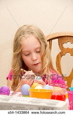 A girl colors eggs for Easter View Large Photo Image Picture - A girl colors eggs for Easter. Fotosearch