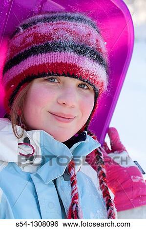 A girl in winter clothing, holding a sled View Large Photo Image Stock Photograph - A girl in winter clothing, holding a sled. Fotosearch
