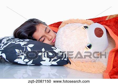 Stock Image - A girl sleeping with her teddy bear, Pune, India.. Fotosearch