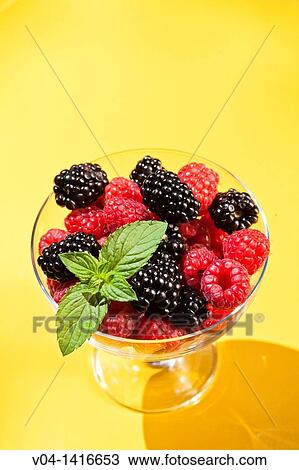A glass bowl filled with raspberries and blackberries on a yellow background View Large Photo Image Stock Image - A glass bowl filled with raspberries and blackberries on a yellow background. Fotosearch