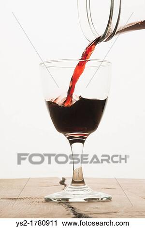 A glass of red wine being filled from a carafe View Large Photo Image Stock Image - A glass of red wine being filled from a carafe. Fotosearch