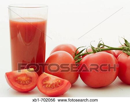 A glass tomato juice, besides are bush tomatoes View Large Photo Image Stock Photograph - A glass tomato juice, besides are bush tomatoes. Fotosearch