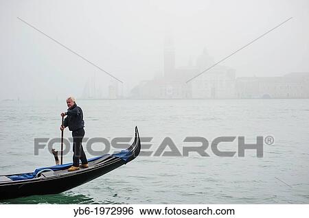A Gondola passing by in front of San Giorgio Maggiore In Venice covered in thick fog, Italy. View Large Photo Image Stock Photograph - A Gondola passing by in front of San Giorgio Maggiore In Venice covered in thick fog, Italy.. Fotosearch