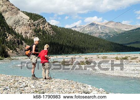A grandmother and her grandson look at a stream south of Bow Lake in Banff National Park, Alberta, Canada View Large Photo Image Stock Image - A grandmother and her grandson look at a stream south of Bow Lake in Banff National Park, Alberta, Canada. Fotosearch