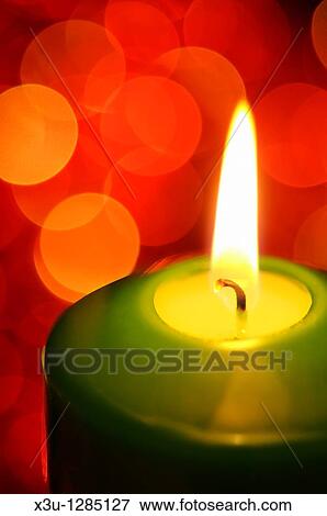 A green candle burning with fairy lights in the background out of focus View Large Photo Image Stock Photo - A green candle burning with fairy lights in the background out of focus. Fotosearch