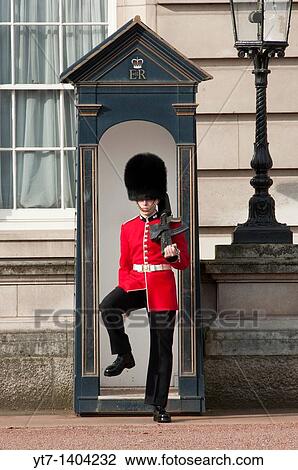Stock Image - A Grenadier guard at Buckingham palace, London. Fotosearch