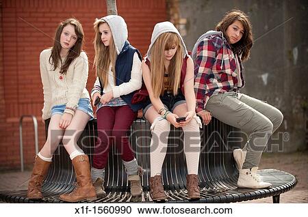 A group of 13 year old teenage girls, looking bored moody with attitude, sitting on a bench UK View Large Photo Image Stock Image - A group of 13 year old teenage girls, looking bored moody with attitude, sitting on a bench UK. Fotosearch