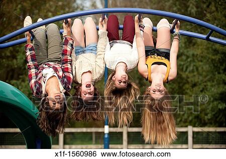 A group of 13 year old teenage girls having fun hanging upside down in a playground UK View Large Photo Image Stock Photograph - A group of 13 year old teenage girls having fun hanging upside down in a playground UK. Fotosearch