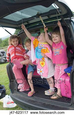 A group of 4, 5 year old girls standing in the back of a people carrier, with the boot up, on camping trip, playing View Large Photo Image Stock Photo - A group of 4, 5 year old girls standing in the back of a people carrier, with the boot up, on camping trip, playing. Fotosearch