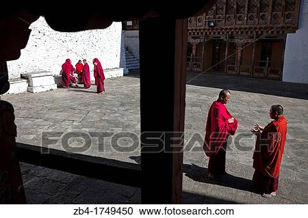 Stock Image - A group of monks in the patio of Trongsa Dzong, Trongsa, Bhutan, Asia.. Fotosearch