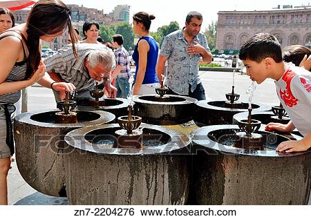 A group of people take a drink from Yerevan's natural drinking water fountains, Armenia. View Large Photo Image Stock Photograph - A group of people take a drink from Yerevan's natural drinking water fountains, Armenia.. Fotosearch