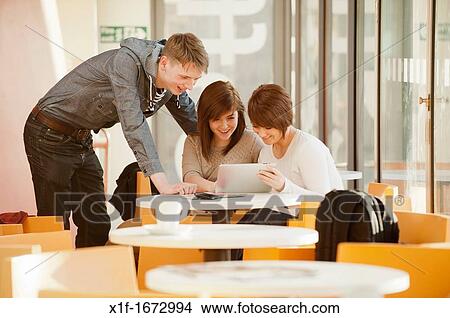 A group of young people - two girls and a boy - talking chatting in a cafe, UK View Large Photo Image Picture - A group of young people - two girls and a boy - talking chatting in a cafe, UK. Fotosearch