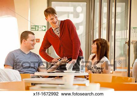 A group of young people - two men and a girl - talking chatting in a cafe, UK View Large Photo Image Stock Image - A group of young people - two men and a girl - talking chatting in a cafe, UK. Fotosearch