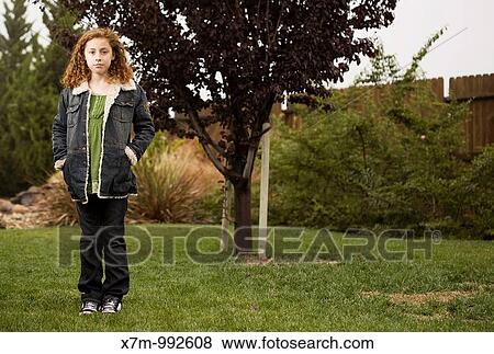 A growing young mixed race mexican & caucasian girl standing in front of a young sapling View Large Photo Image Stock Photo - A growing young mixed race mexican & caucasian girl standing in front of a young sapling. Fotosearch