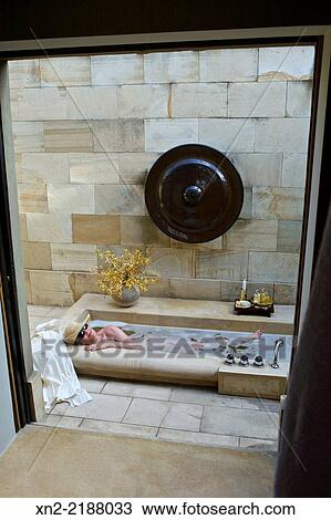 A guest stretches out in an outdoor bath on private patio in a suite at Amanjiwo resort, near Borobudur, Magelang, Central Java, Indonesia View Large Photo Image Stock Image - A guest stretches out in an outdoor bath on private patio in a suite at Amanjiwo resort, near Borobudur, Magelang, Central Java, Indonesia. Fotosearch